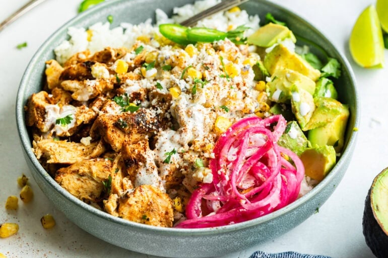 a chicken rice power bowl with creamy mexican street corn, avocado, pickled red onions and jalapenos