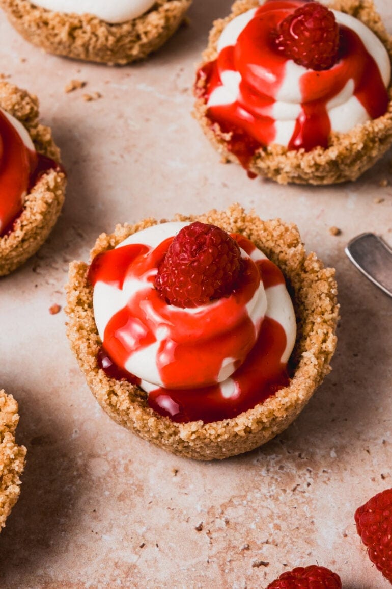 mini cheesecakes drizzled with bright, fruity raspberry sauce.