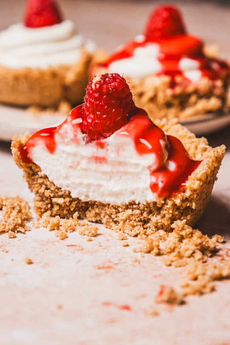 No-bake mini cheesecakes with raspberry sauce and a raspberry garnish