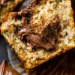 A soft banana muffin cut in half with a dollop of nutella spilling out of the center