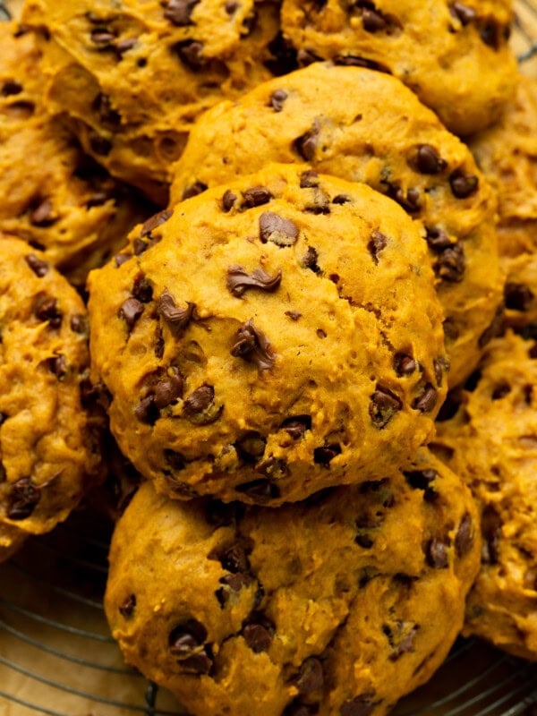 a photo of baked pumpkin chocolate chip cookies piled on top of each other
