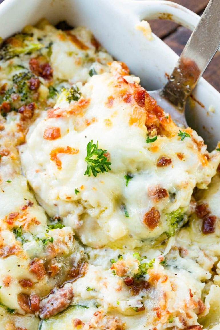 a photo of a serving of white vegetable lasagna being scooped out of a full pan of it
