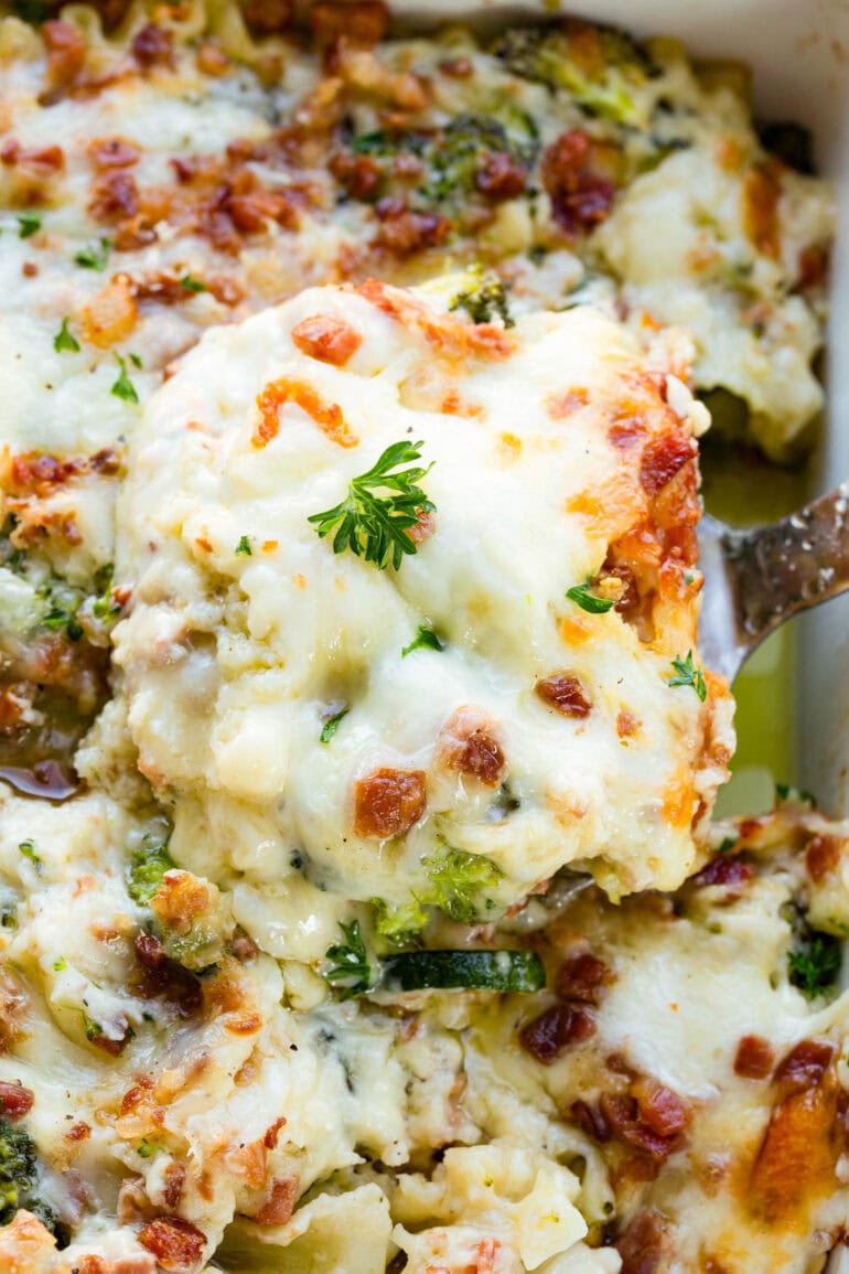 a photo of a serving of golden baked lasagna being lifted out of a pan full of lasagna
