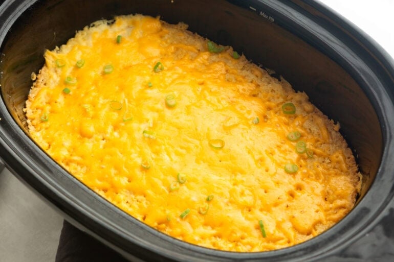 a baked cheesy corn casserole in a crock pot