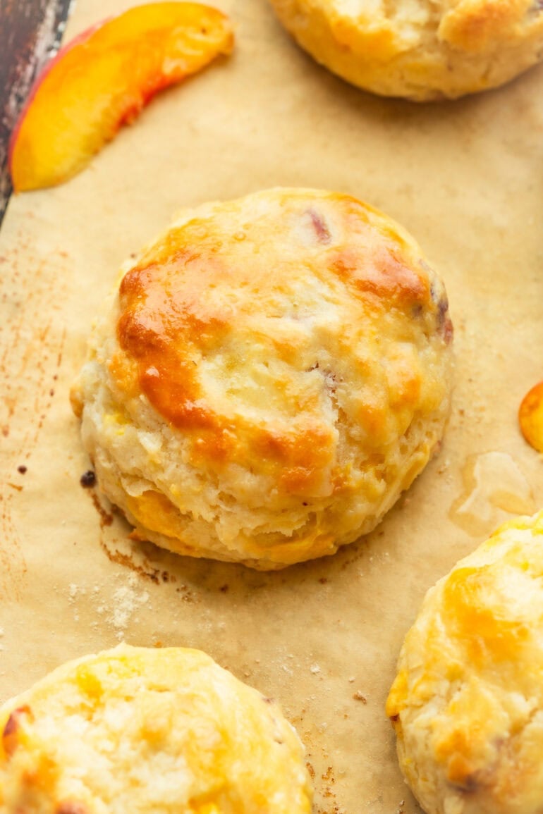 A flaky pastry sitting on parchment paper with fruit 