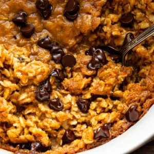 a pumpkin chocolate chip baked oatmeal with a spoon scooping up a serving