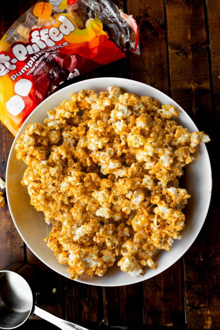 a large white bowl full of gooey pumpkin spice marshmallow popcorn
