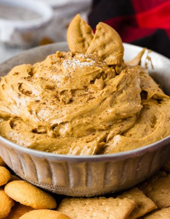 a silver bowl full of fluffy gingerbread cookie dip or molasses cookie dip with graham crackers and nilla wafers