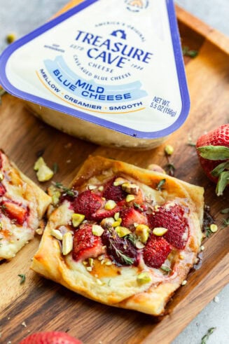 a photo of a roasted strawberry blue cheese tart with a package of treasure cave blue cheese in the background