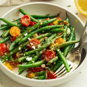 Top view of Sautéed Green Beans and Cherry Tomatoes in a white bowl.
