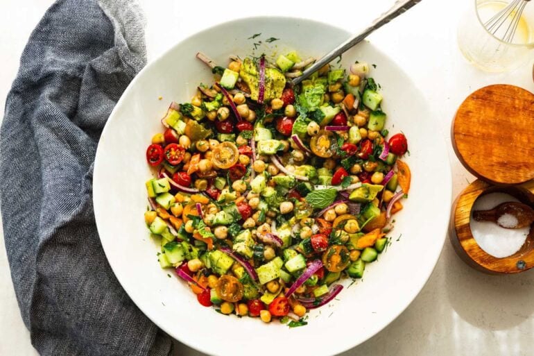 a large white serving bowl full of chickpea salad