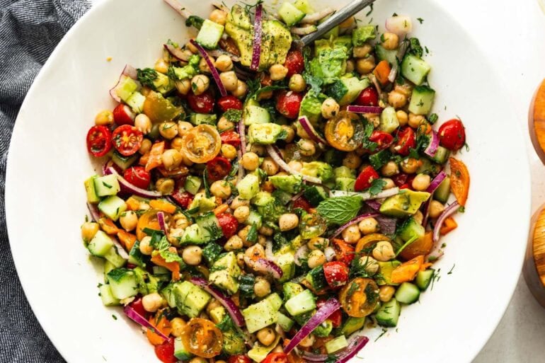 a large bowl of chickpea salad with fresh herbs and a lemon dressing