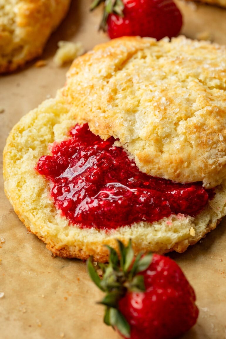 a golden sweet cream biscuit sliced in half with strawberry jam in the biscuit