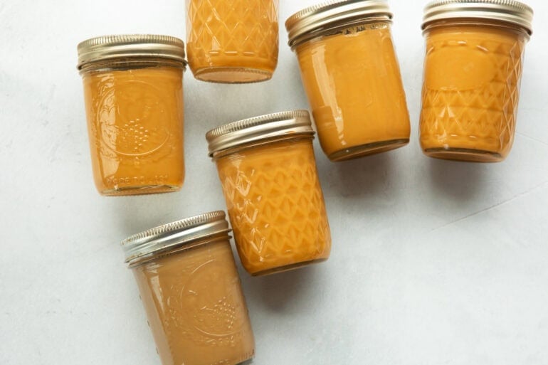 Jars of caramel sauce made with a recipe titled how to make caramel with condensed milk