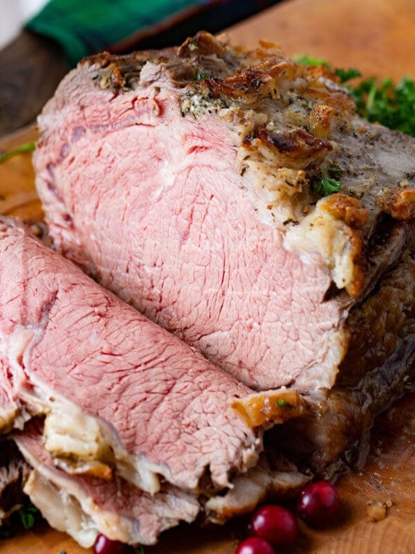 A photo of slow cooker prime rib half sliced on a cutting board