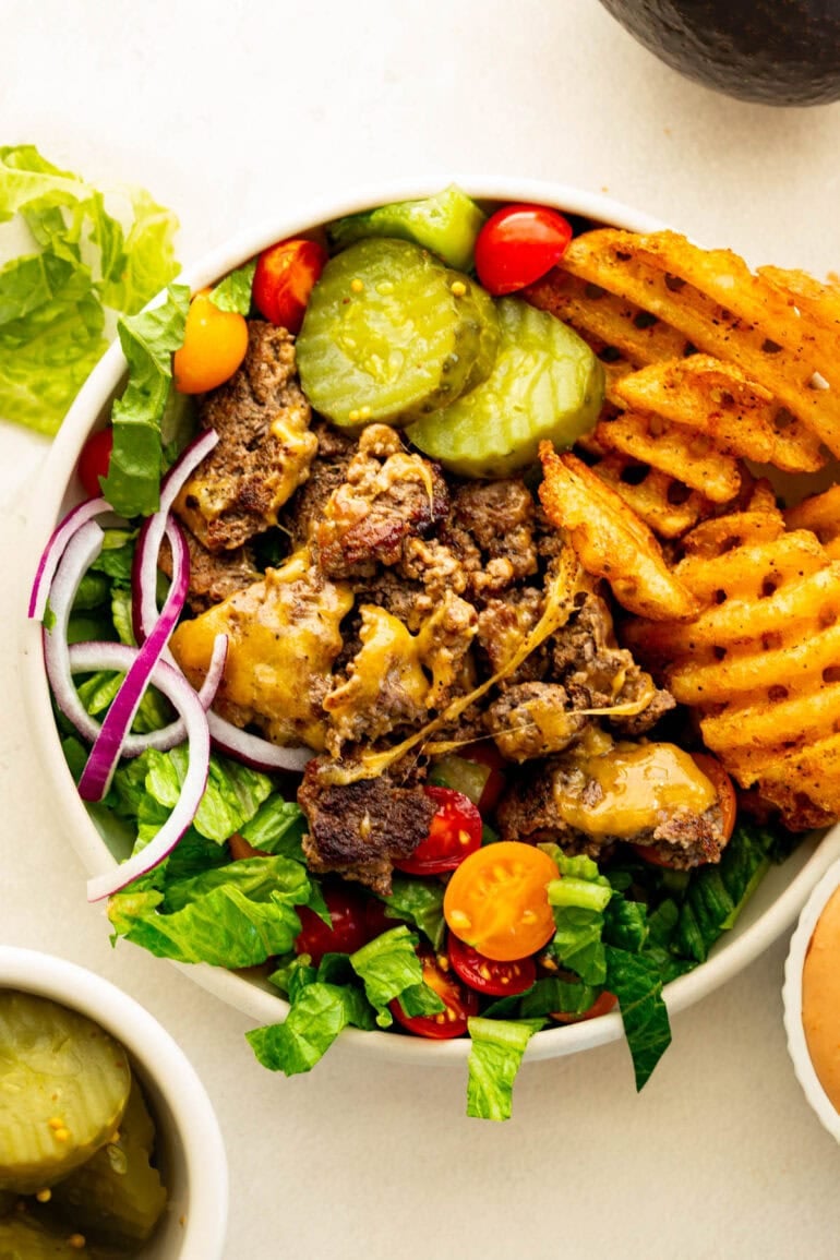 Viral burger bowl recipe with cheesy ground beef, waffle fries and fresh burger toppings