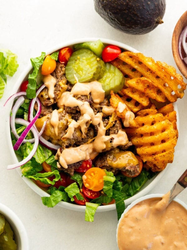 Smash burger bowl with crispy ground beef, waffle fries, romaine, tomatoes, cheese, pickles and burger sauce