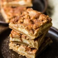 Snickerdoodle cookie dough crust, a cheesecake filling and more snickerdoodle cookies on top for the most fantastic snickerdoodle cheesecake bars ever