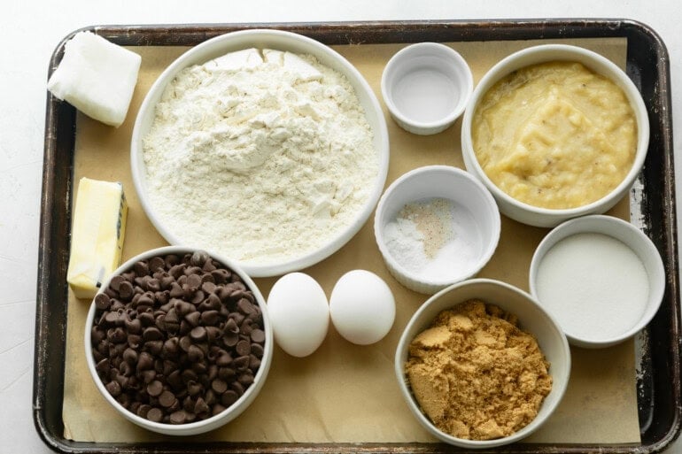 all the ingredients for chewy banana cookies with chocolate chips in separate small bowls
