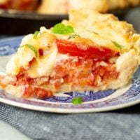 a slice of southern tomato pie on a blue china plate