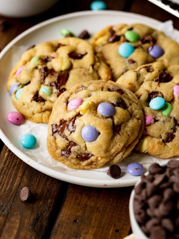 a photo of a white serving plate full of thick and golden Easter m&m chocolate chip cookies.