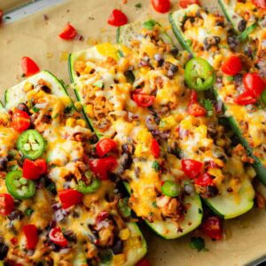 several zucchini boats loaded with taco filling and melty cheese