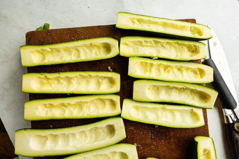several zucchinis that have been halved and had the middles scooped out for zucchini boats