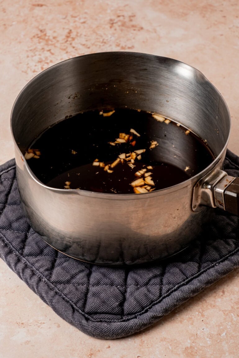 a saucepan of homemade teriyaki sauce sitting on a cooling pad