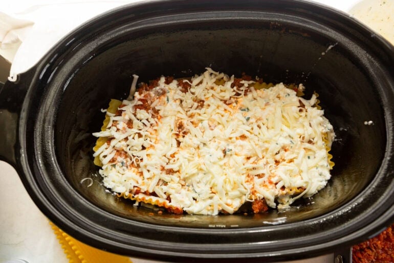 Shredded mozzarella layered over cottage cheese for slow cooker lasagna