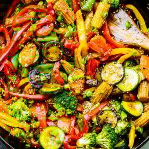 a photo of bright and colorful stir fry vegetables in a large cast iron skillet
