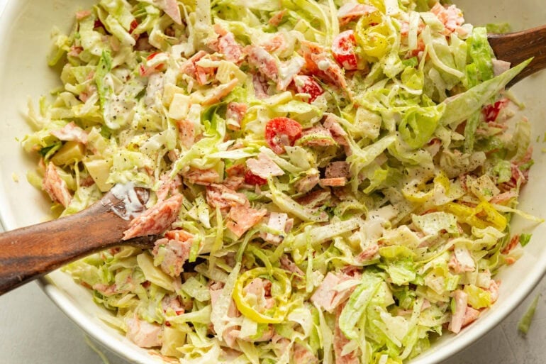 a large white bowl full of a creamy grinder salad