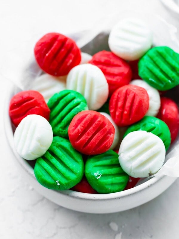 a small bowl full of red, white and green cream cheese mints