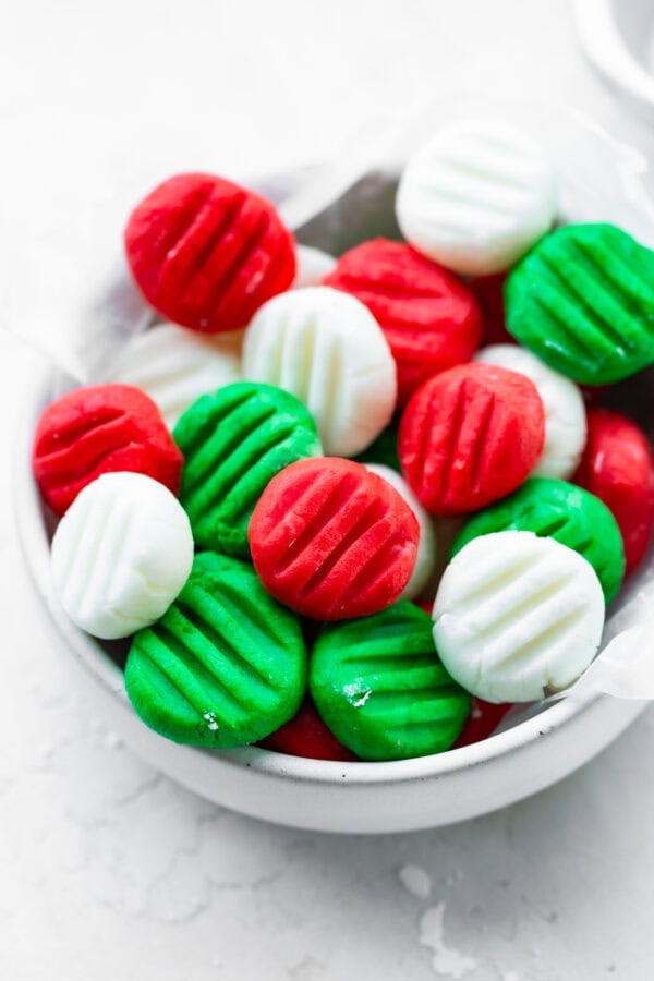 a small bowl full of red, white and green cream cheese mints