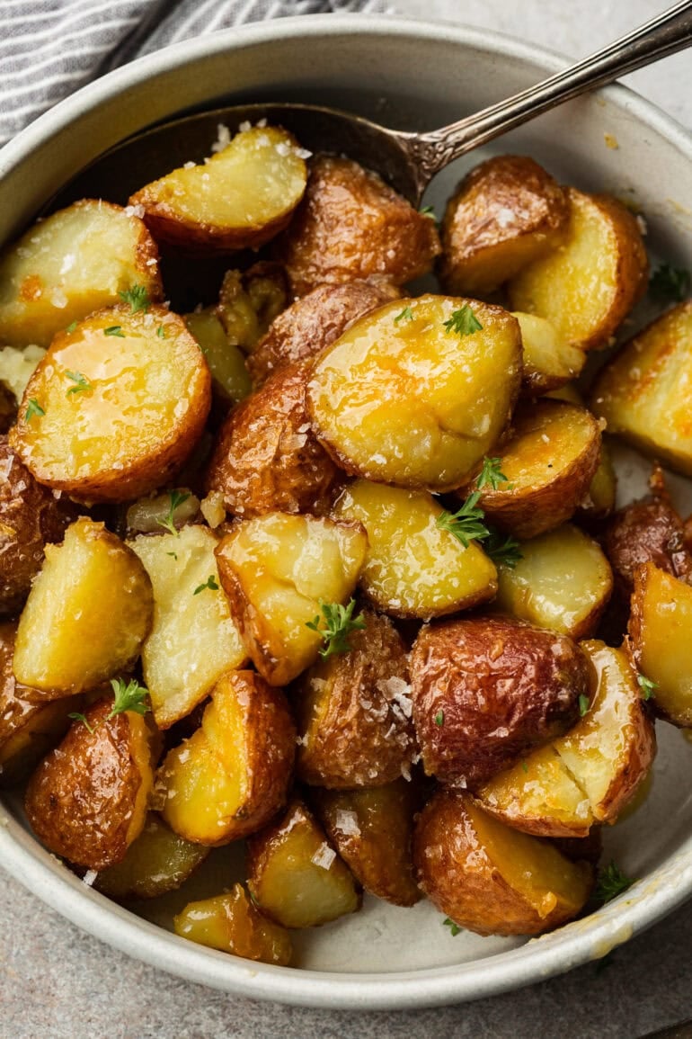 Soft, fluffy starchy vegetables with crispy outside, sitting in a simple white bowl to make their color and texture pop.