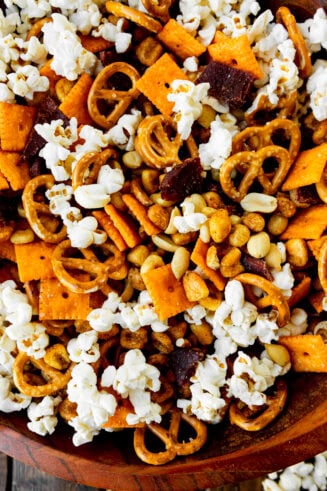 a photo taken over the top of a snack mix loaded with popcorn, pretzels, cheezits, peanuts and beef jerky
