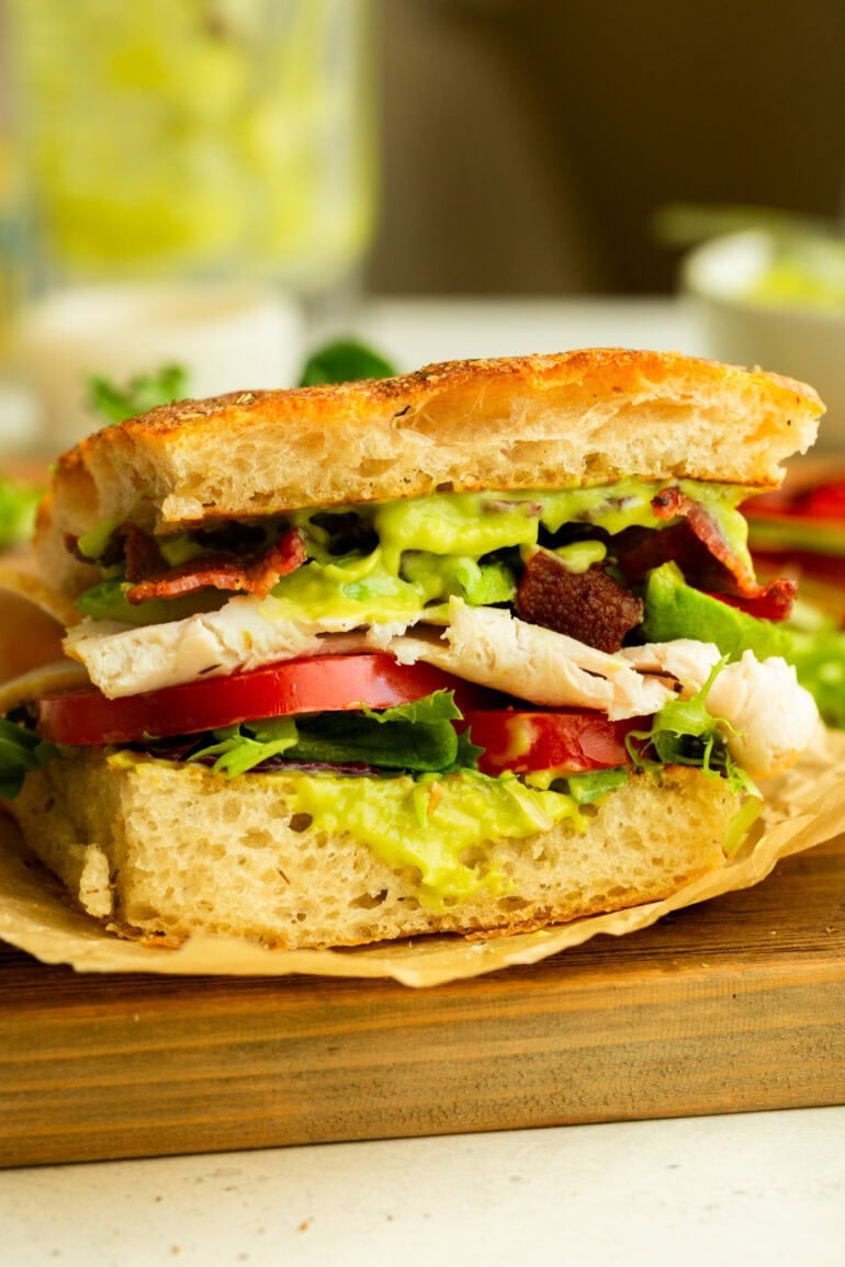 half of a turkey bacon avocado sandwich on focaccia bread
