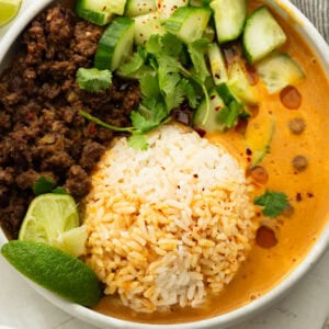 Viral beef broth bowl with crispy ground beef, white rice, creamy coconut curry broth, cucumber, cilantro and lime