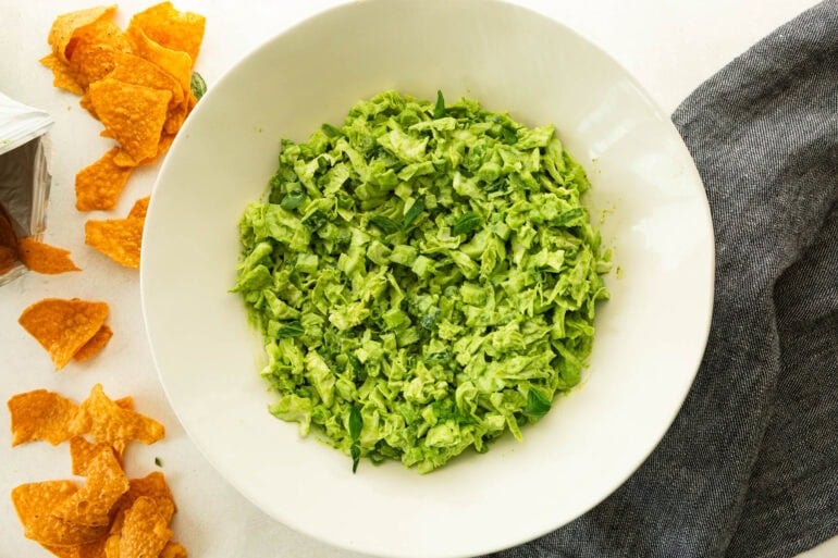 chopped green goddess salad in a large white serving bowl