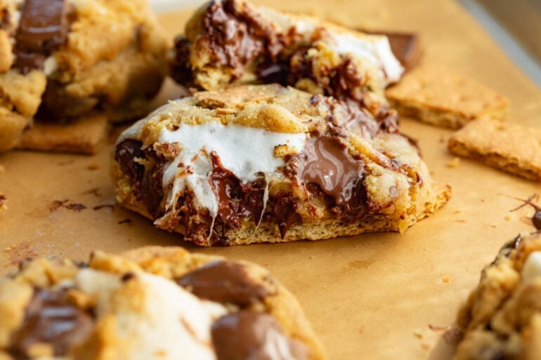 a gooey marshmallow stuffed s'more cookie that has been broken in half so you can see the inside