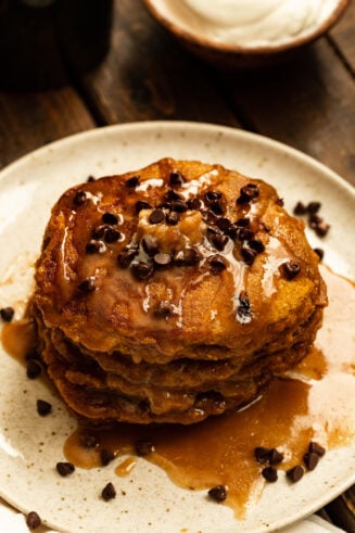 a photo of a stack of whole wheat pumpkin pancakes topped with syrup and mini chocolate chips