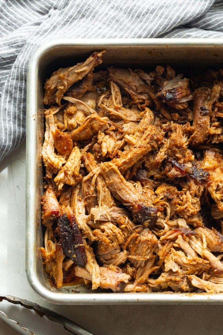 a roasting pan full of juicy shredded pulled pork