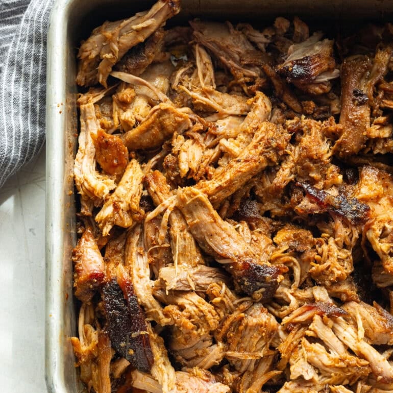 a metal pan full of shredded juicy pulled pork